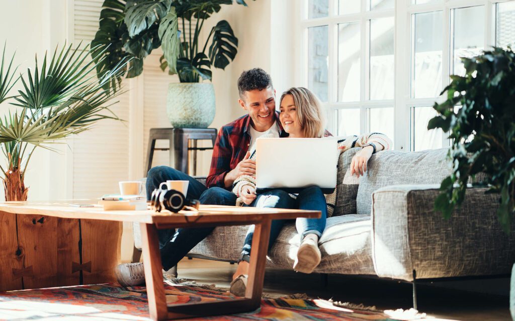 Homepage - Young Couple Sitting on the Couch Going Over Insurance Options