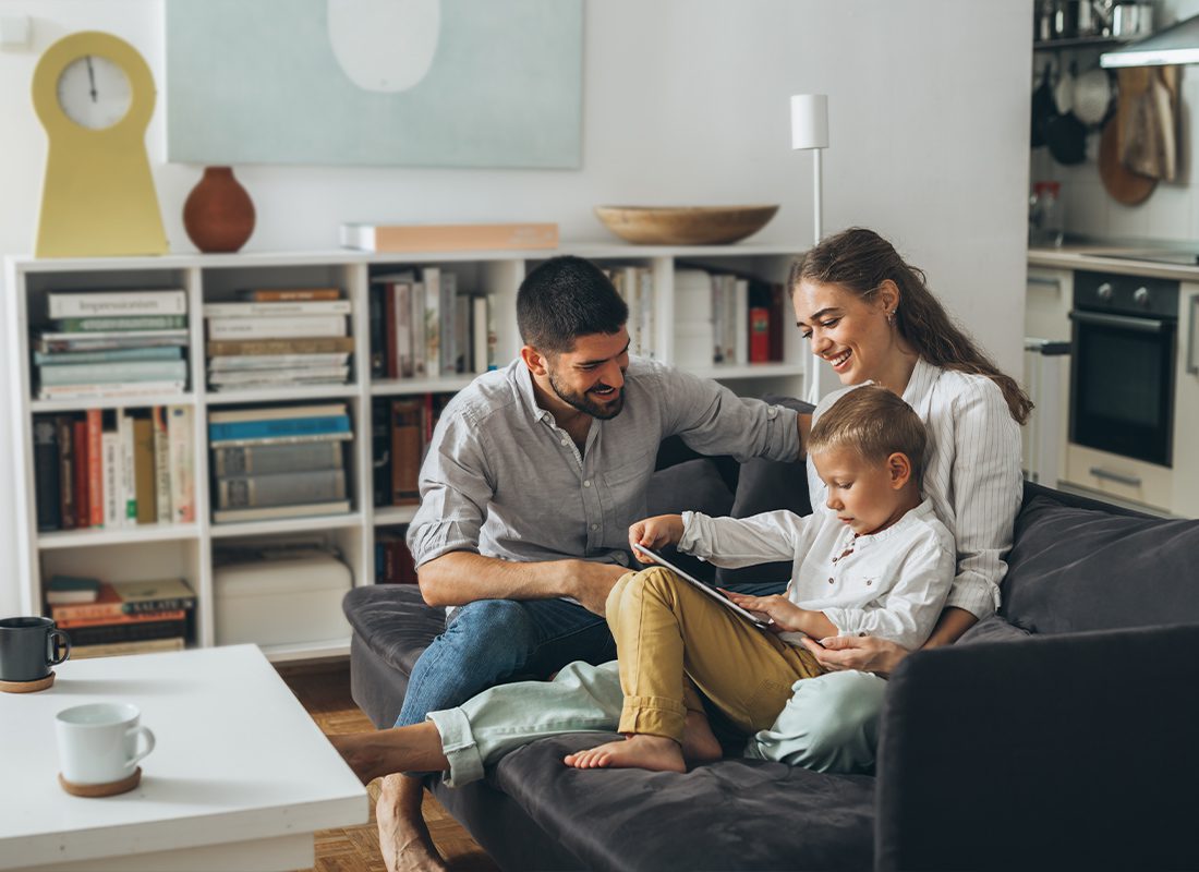 Personal Insurance - Happy Family Spending Time Together Using Tablet and Computer at Home
