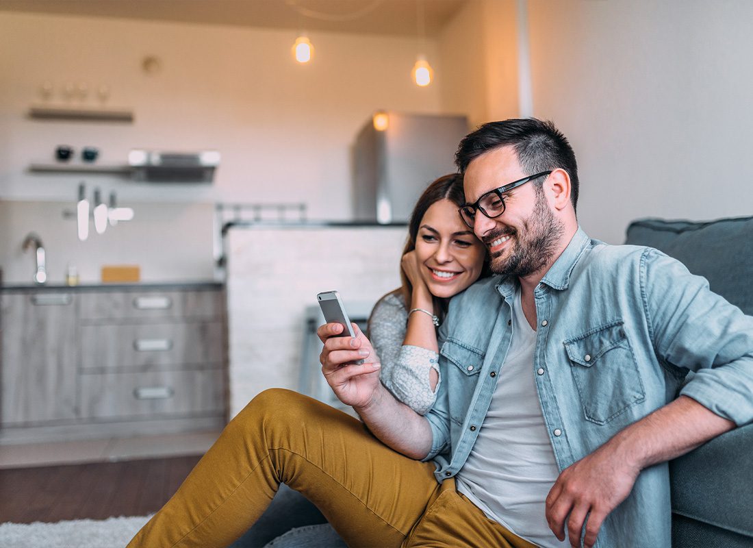 Read Our Reviews - Close-up Image of Couple Watching a Smartphone Screen Indoors